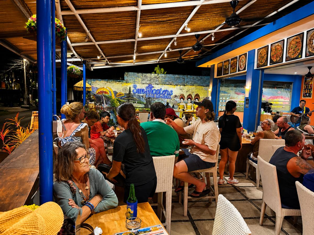 The courtyard & mural, after dark — Sun Shooters Bar & Grill, Kerobokan